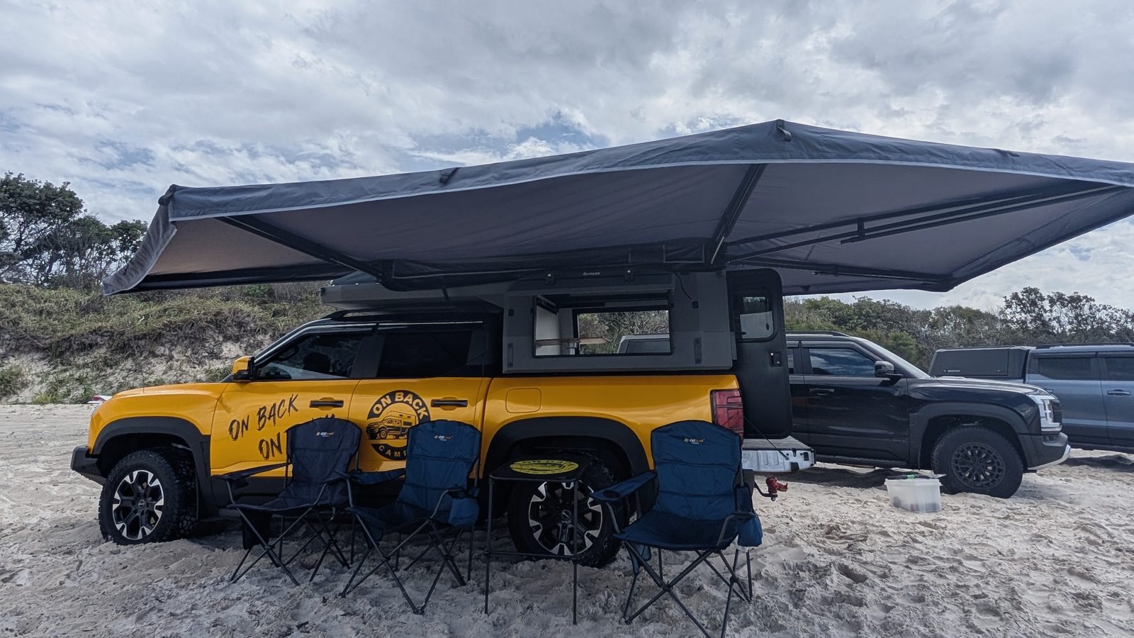 On Back Camper with 270° awning set up on the beach